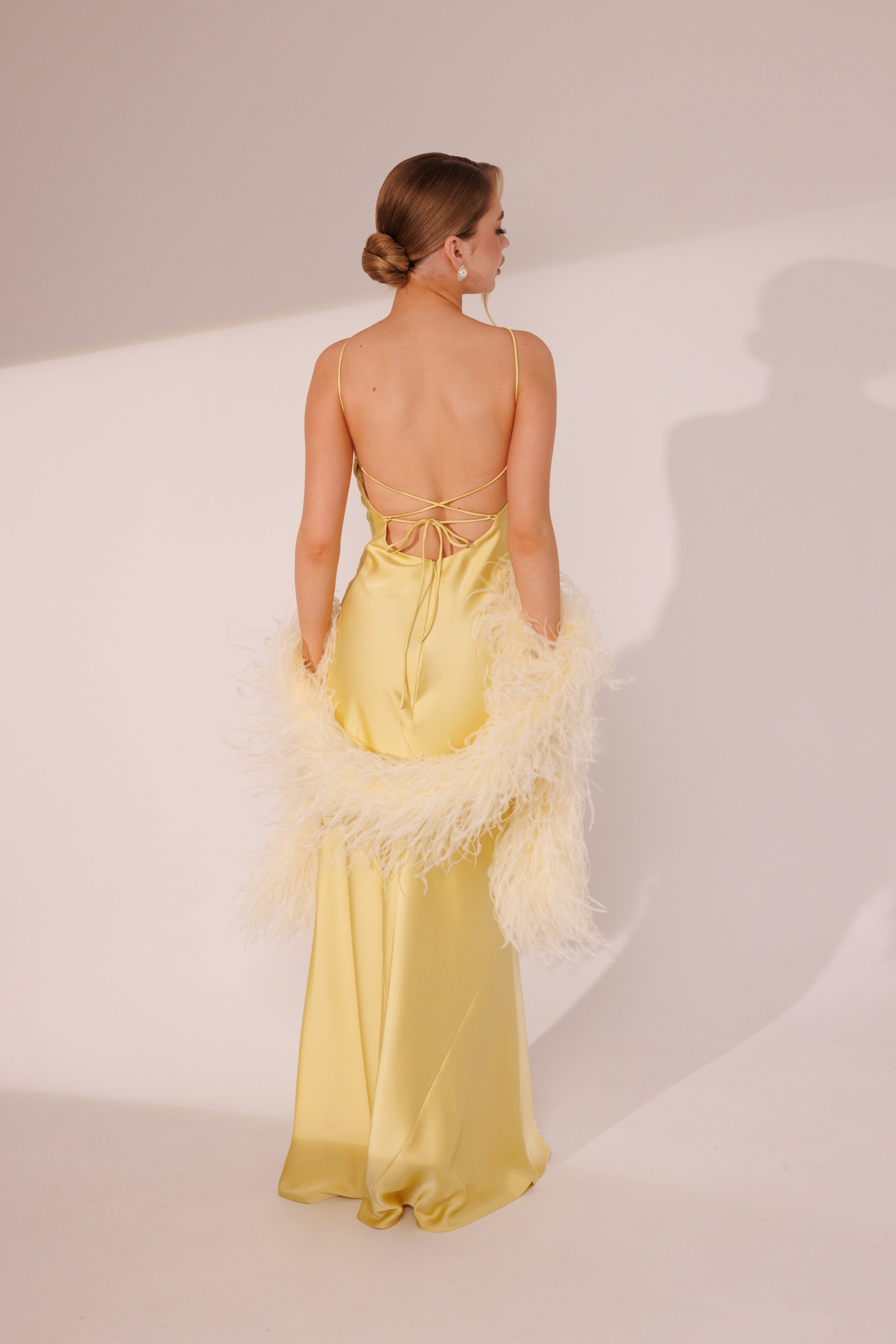 Back view of Elara yellow maxi dress with feather boa detail