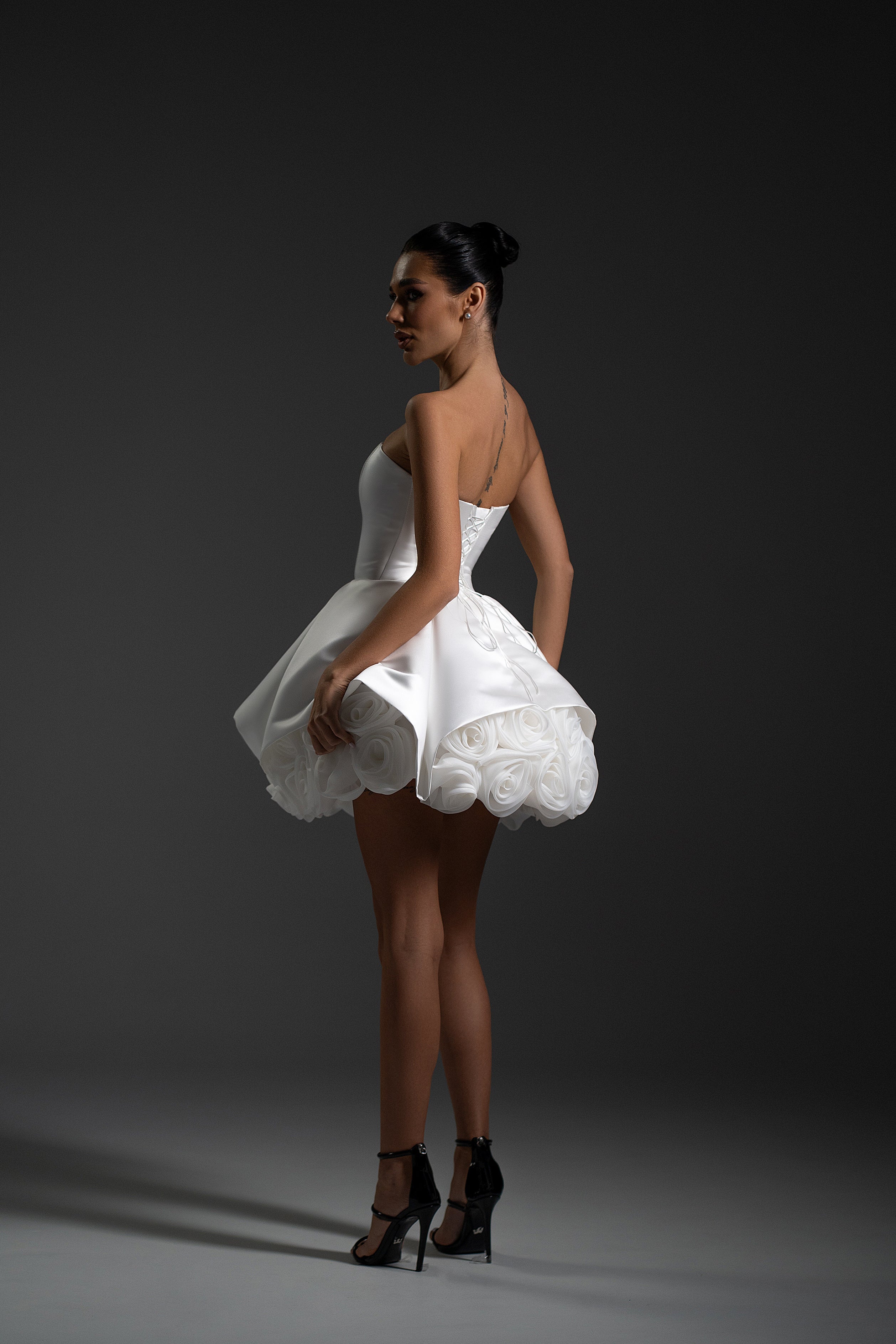 Model wearing La Rose white strapless mini dress with sculpted skirt