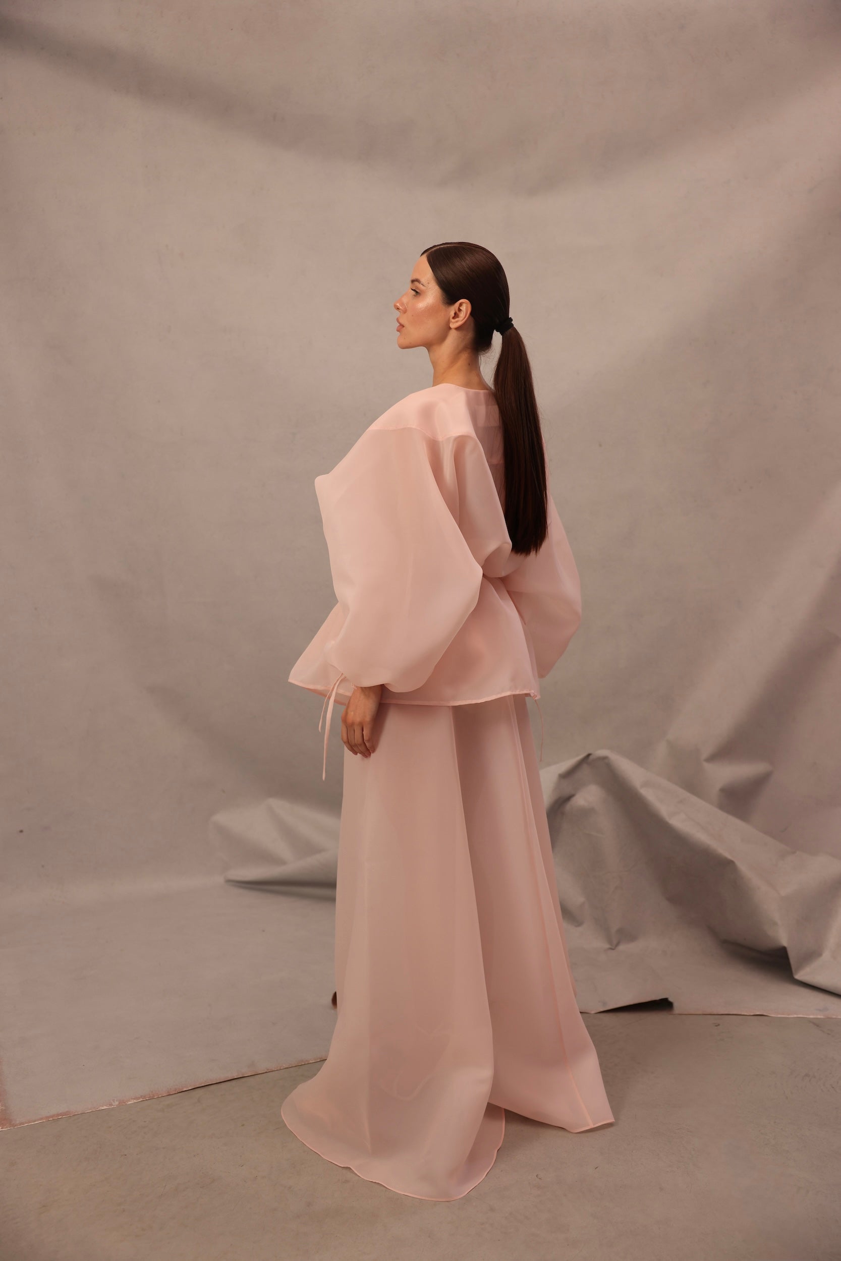 Back view of Set Comte in pink-peach color with flowing sheer trousers
