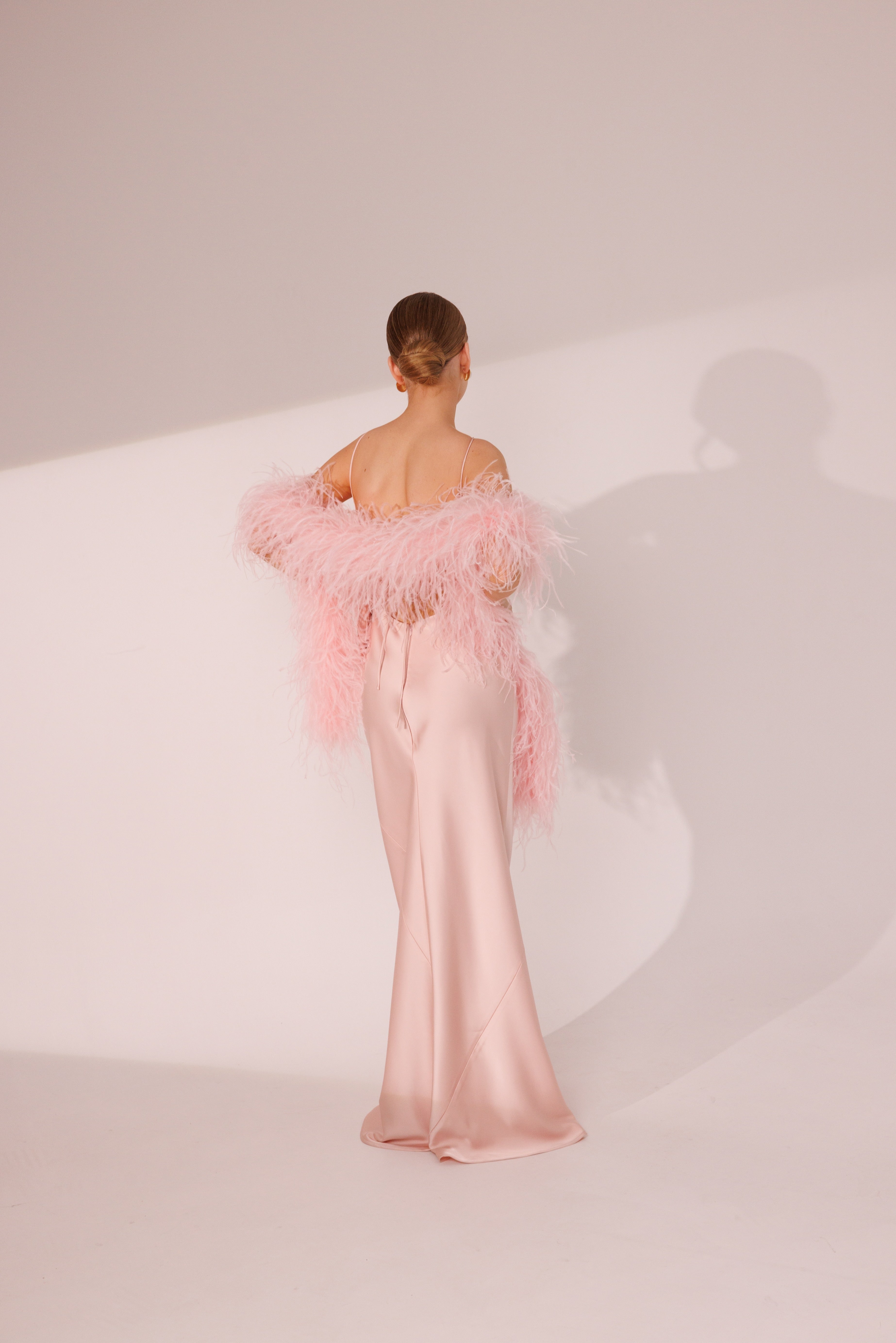 Back view of Elara pink maxi dress with feather boa styling