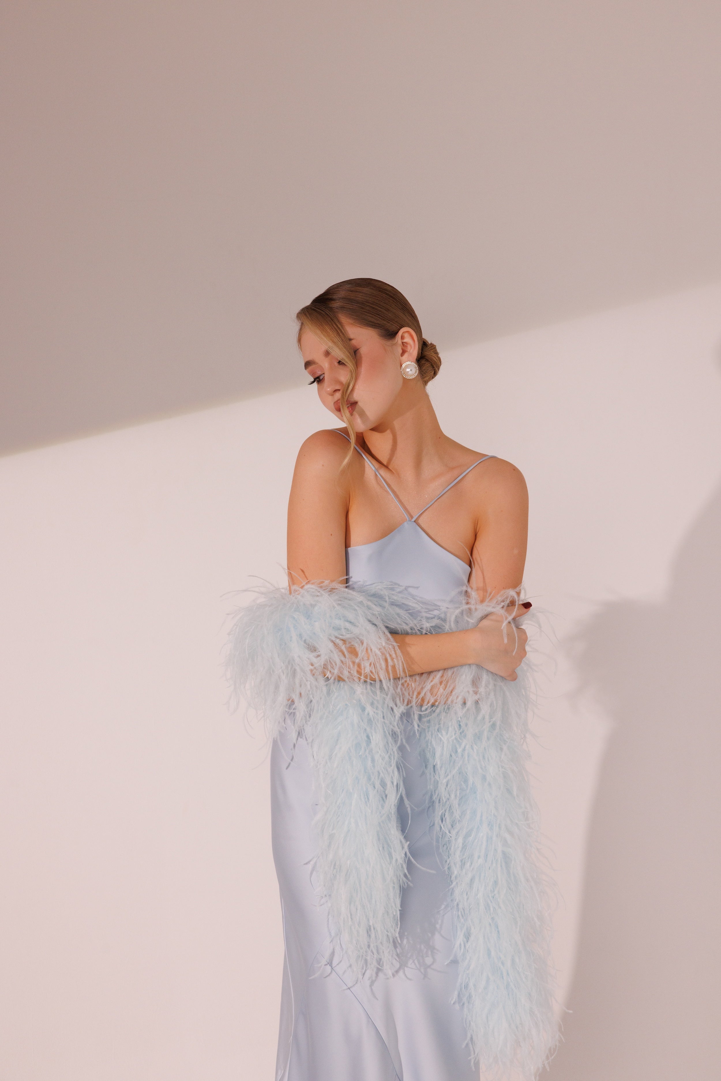 Model wearing blue ostrich feather boa with elegant evening dress